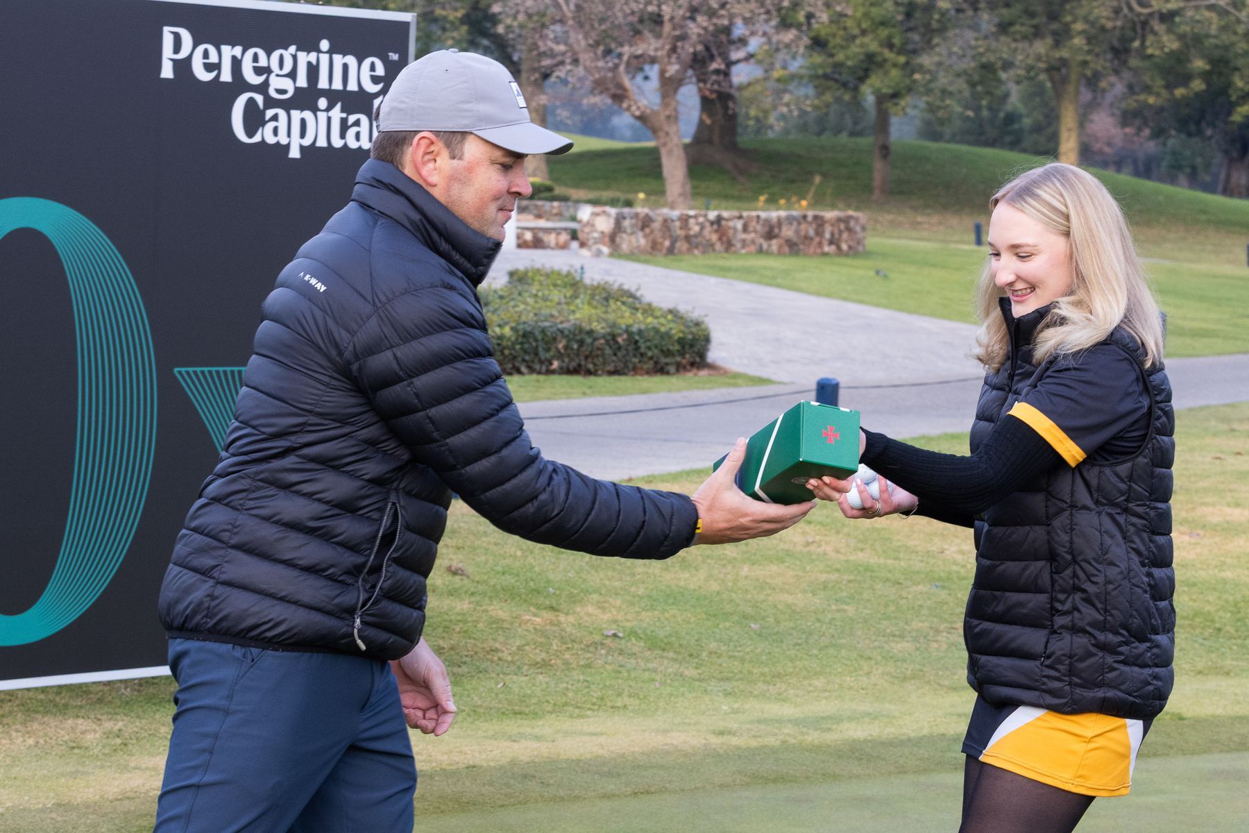 StuSta staff member handing a gift to a golfer on the course